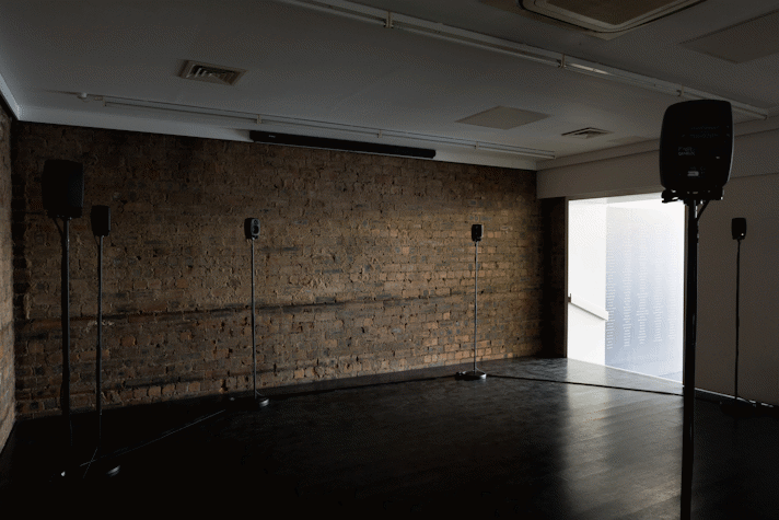 a dark room with speakers on stands