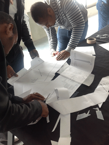 Group of people around a table cutting up sections of paper
